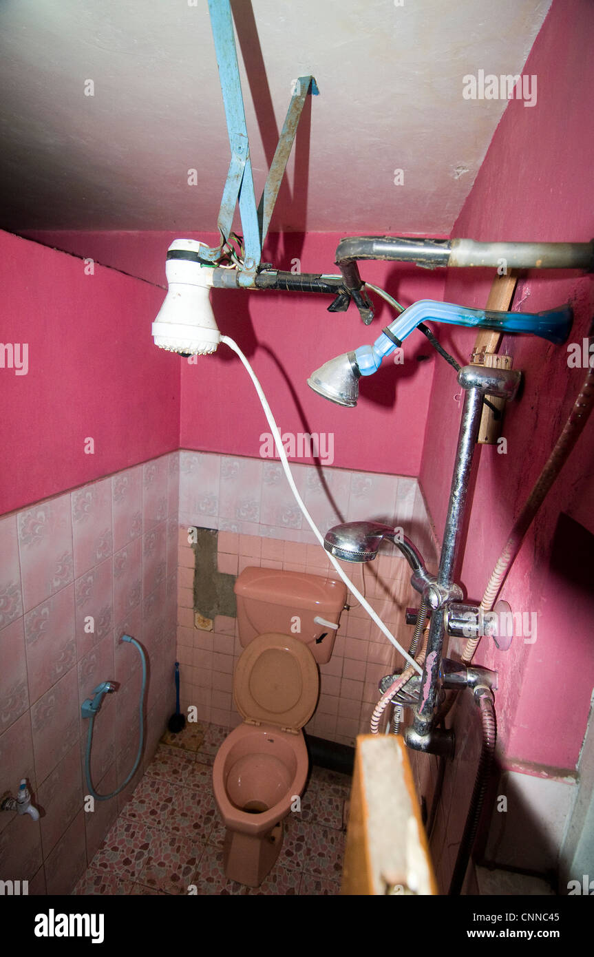 A dangerous bathroom with three shower outlets and electric wires all
