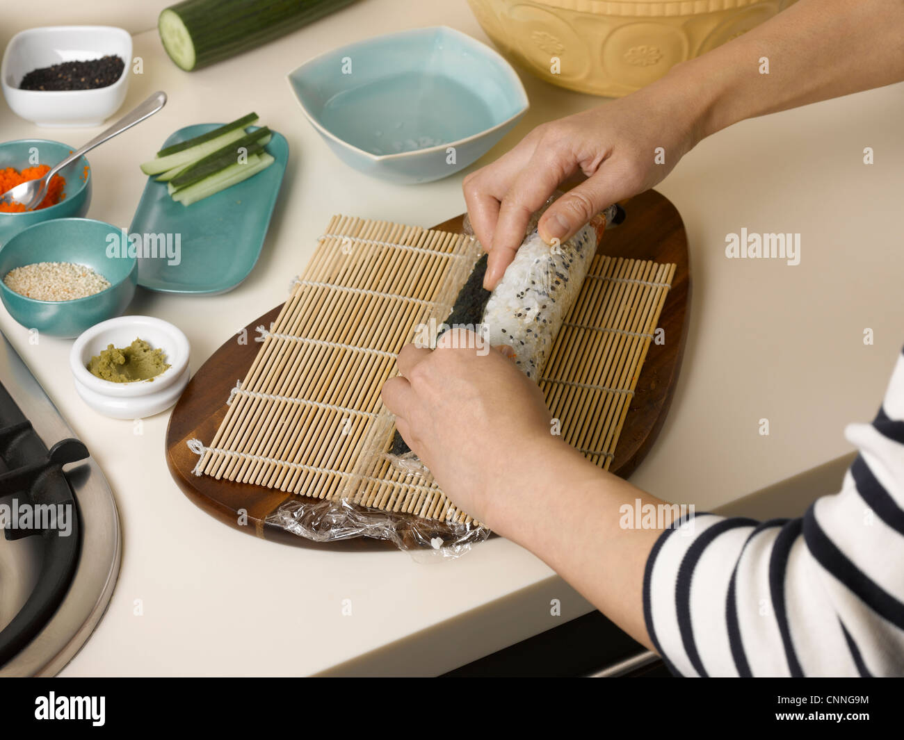 Woman rolling sushi at table Stock Photo Alamy