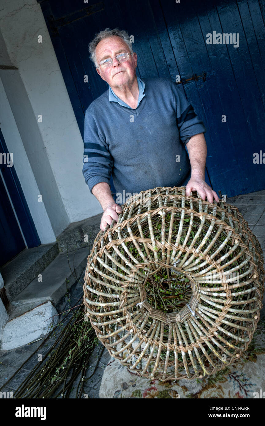 David Cotton, the last maker of traditional crab / lobster pots in Mousehole, Cornwall, UK with one of his pots. Stock Photo