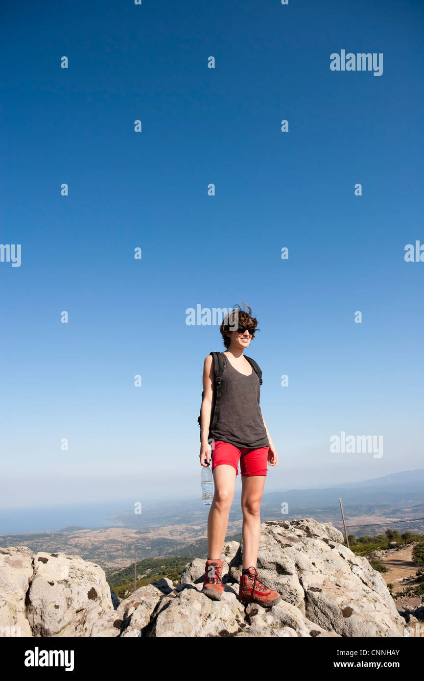 Hiker standing on rocks on hill Stock Photo
