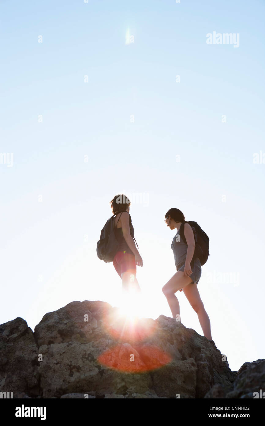 Silhouette of hikers standing on rock Stock Photo - Alamy