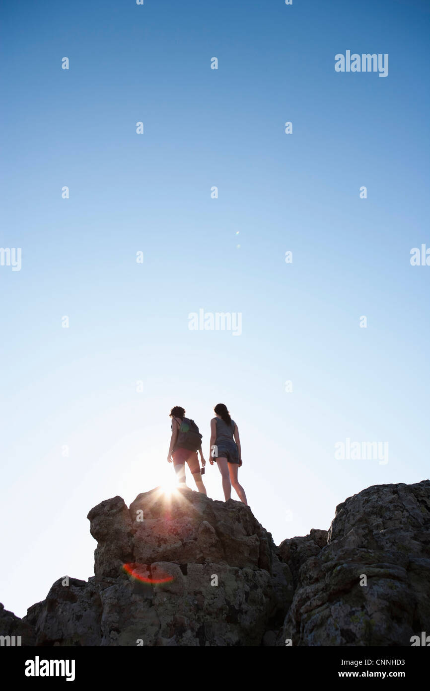 Silhouette of hikers standing on rock Stock Photo - Alamy
