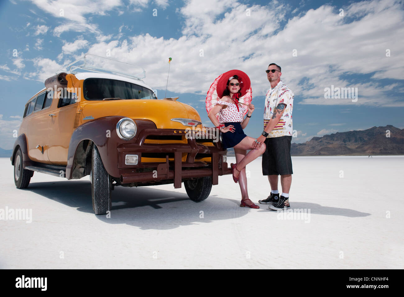 1950s period style nostalgic style man and woman at bonneville salt flats with retro clothing and truck Stock Photo