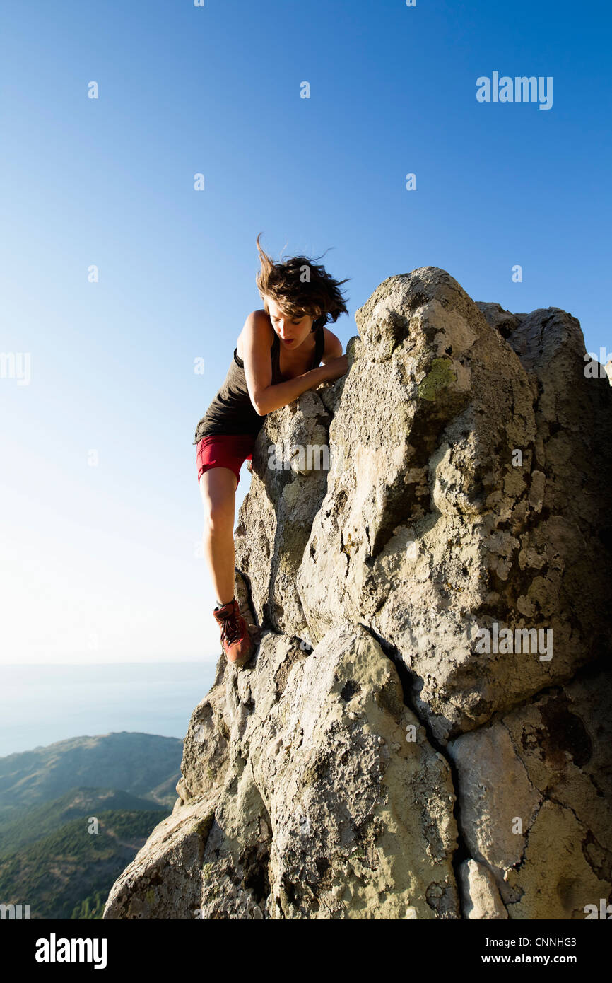 Hiker climbing rocks on hill Stock Photo - Alamy