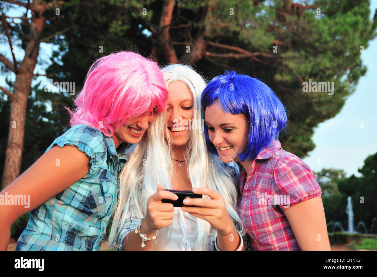 Teenage girls wearing colorful wigs Stock Photo