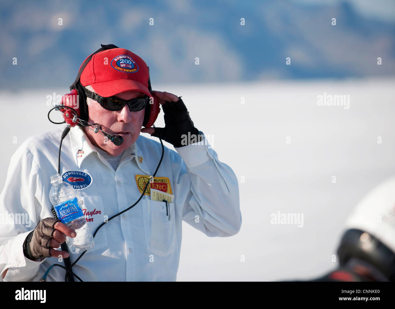 Old race marshal in red hat and headphones Bonneville speed week salt flats Stock Photo