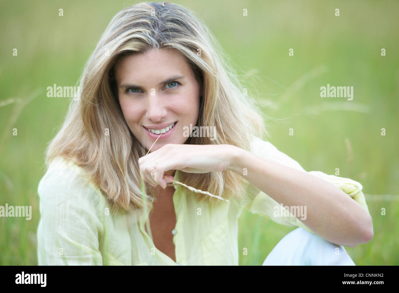 Smiling woman sitting in wheat field Stock Photo - Alamy