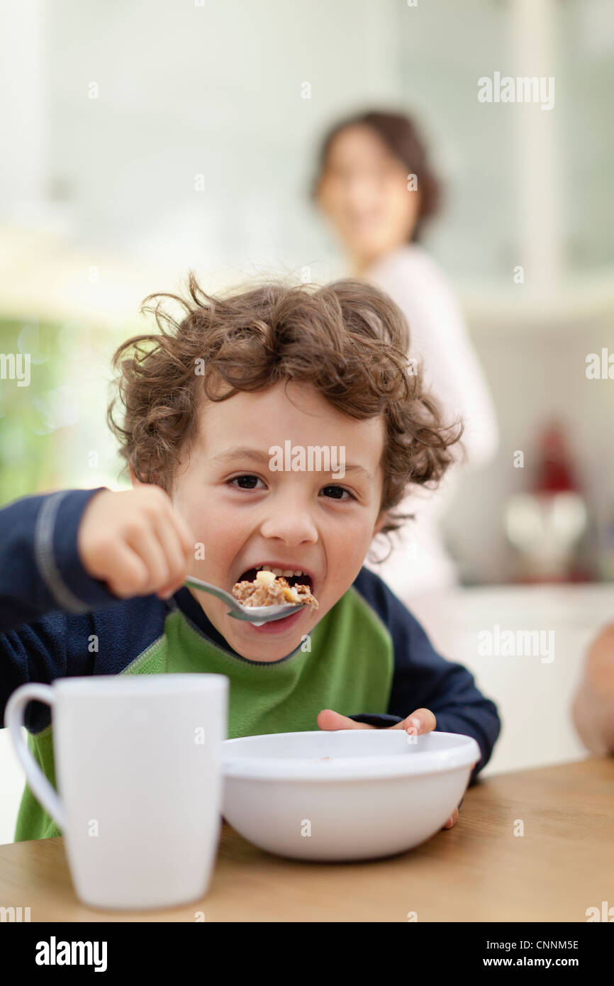 Boy eating breakfast in kitchen Stock Photo