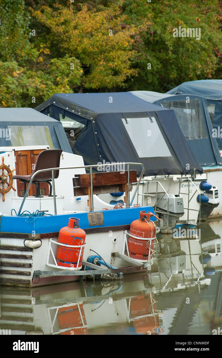 Row of boats moored in a marina with one carrying bottles of propane gas Stock Photo Alamy