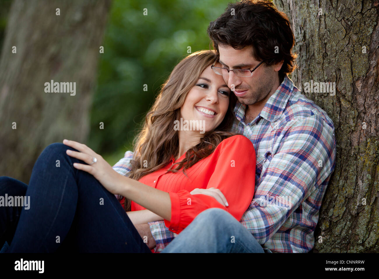 Close-up Portrait of Young Couple Sitting in Park Stock Photo - Alamy