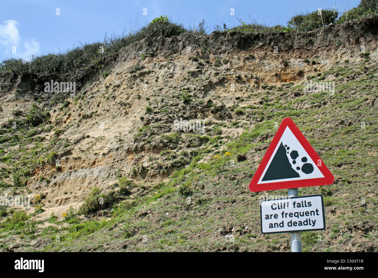'Cliff falls are frequent and deadly' sign beside coastal cliff erosion, Dunwich, Suffolk, England, july Stock Photo