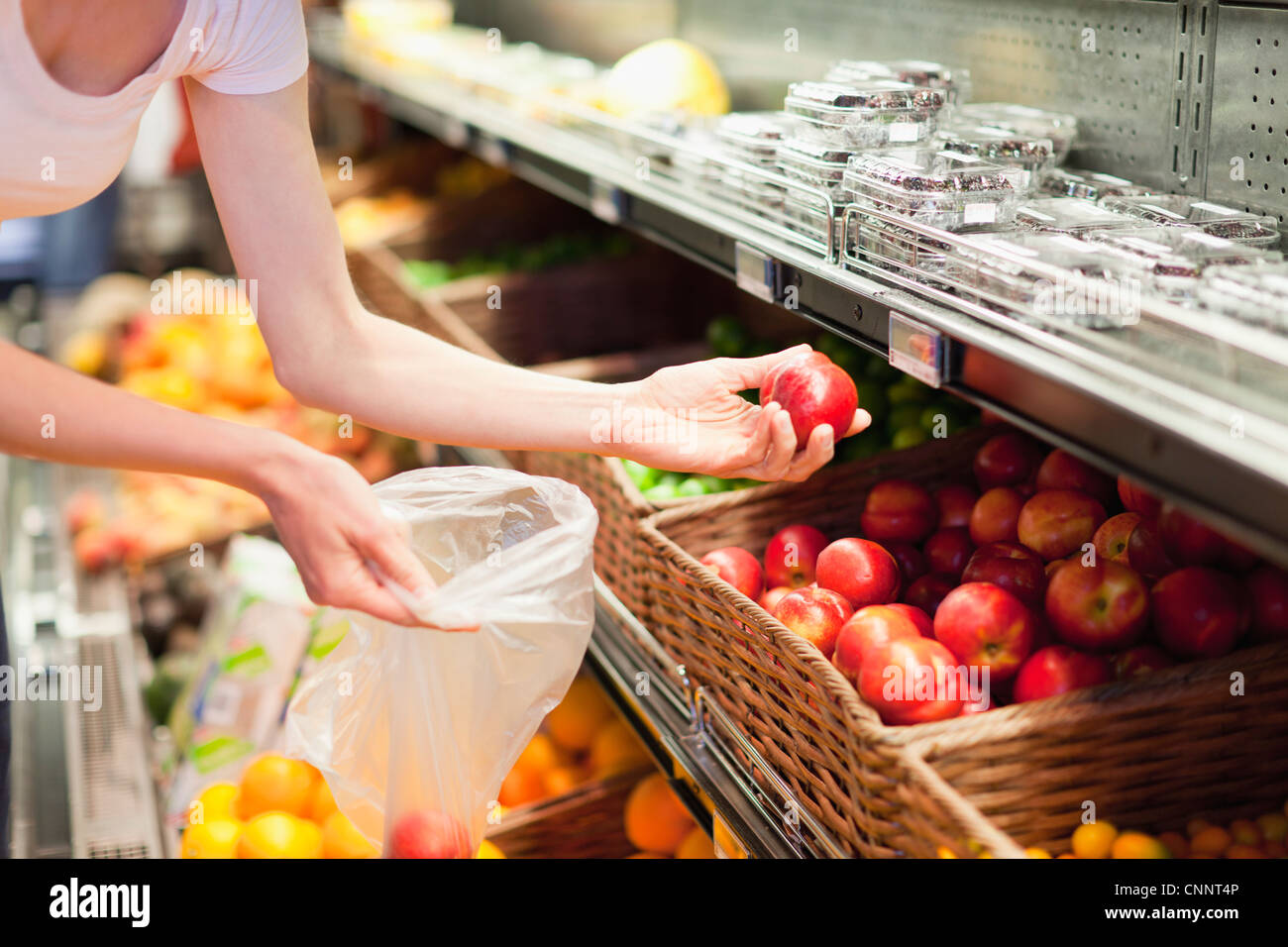Woman selecting fruit at grocery store Stock Photo