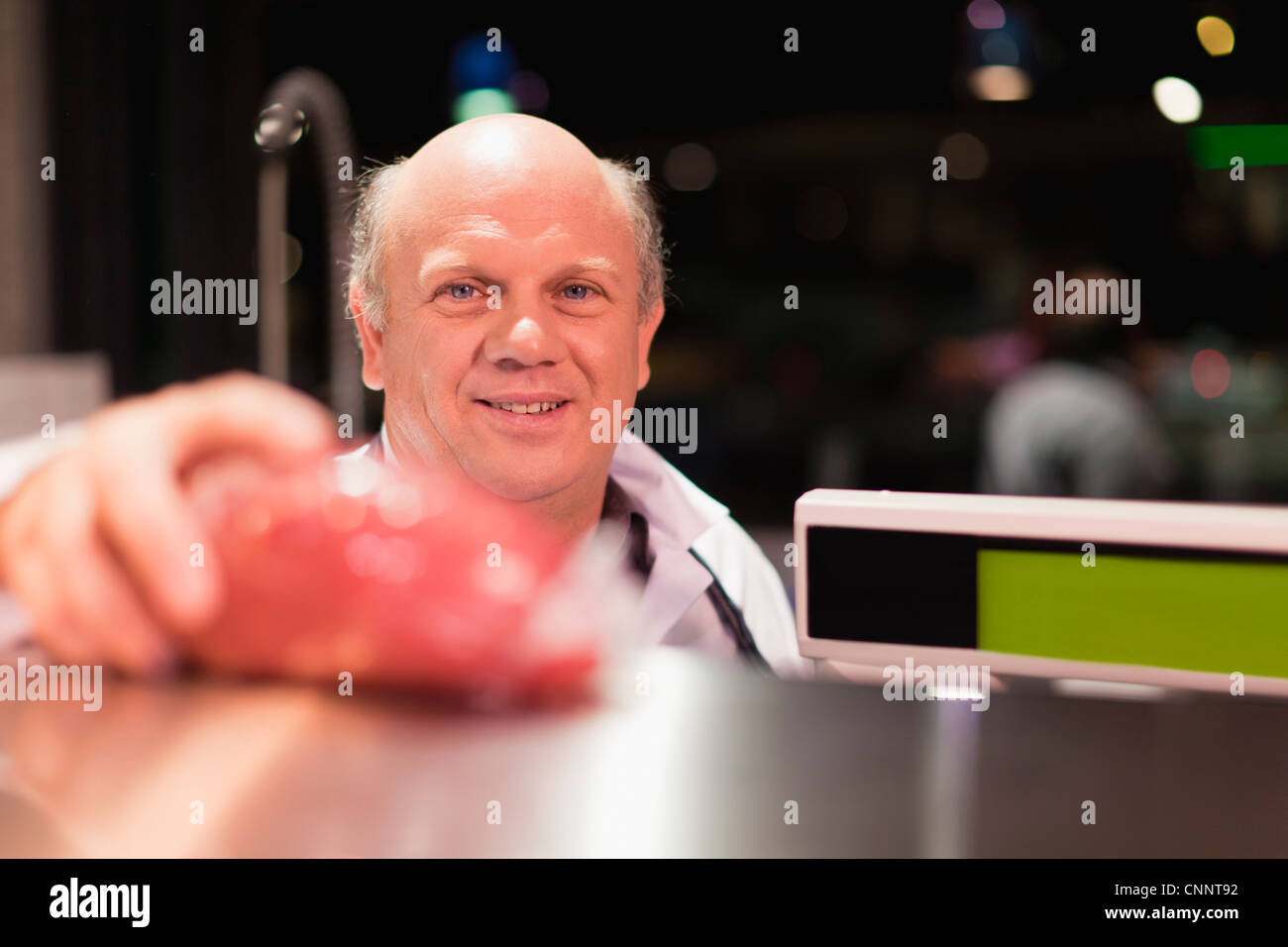 Butcher weighing meat Stock Photo