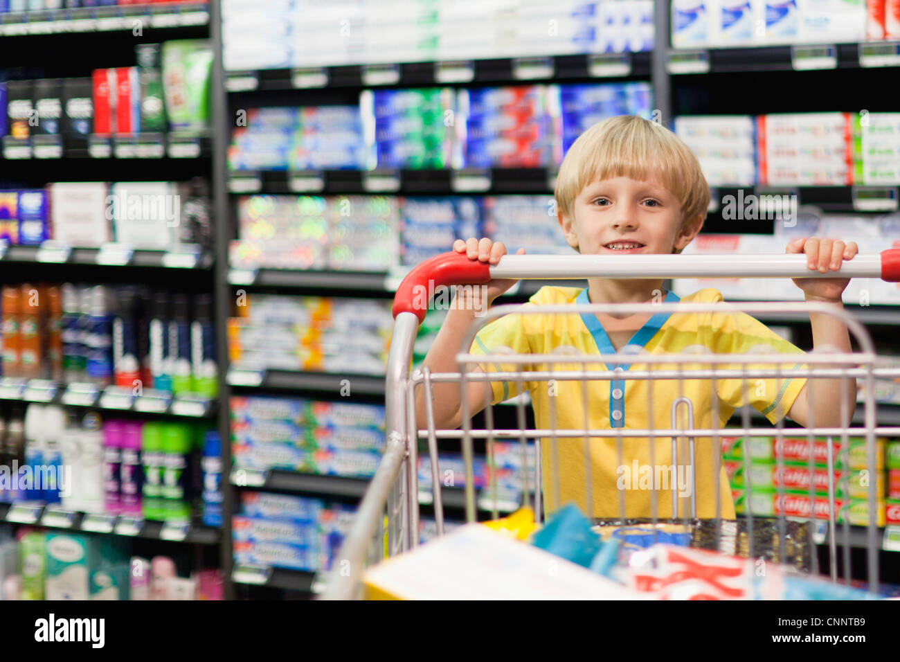 Boy pushing cart in grocery store Stock Photo Alamy