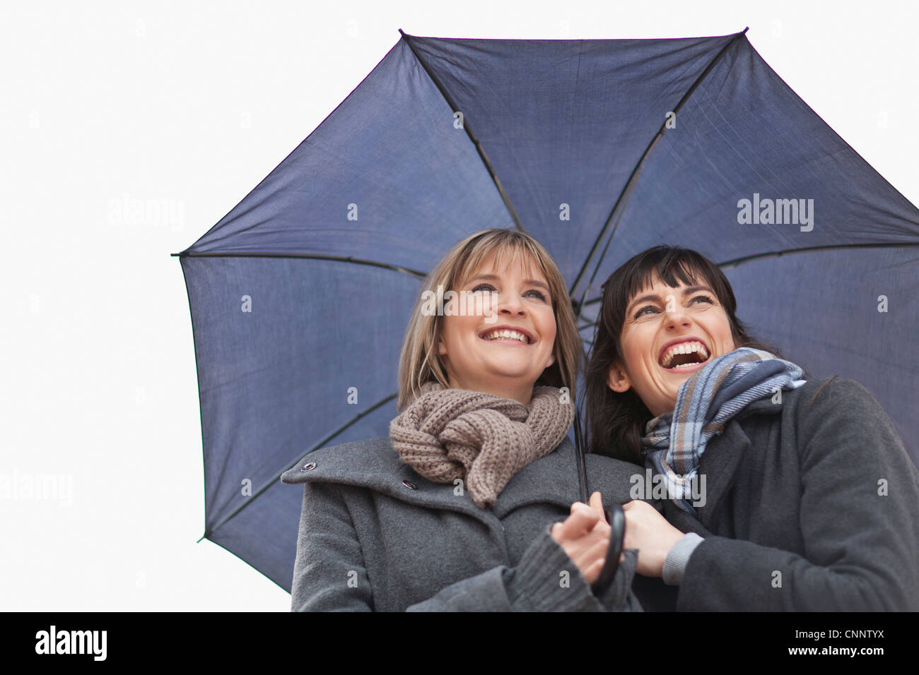 Smiling women under umbrella Stock Photo