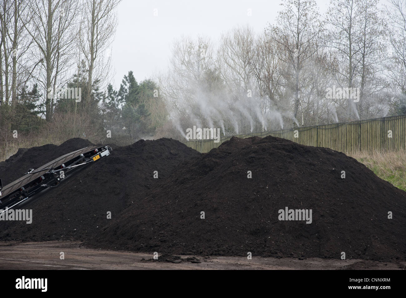 Peppermint perfume spraying over green compost heap at municipal waste site, near Chester, Cheshire, England, march Stock Photo
