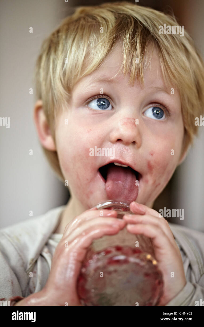 Boy eating jam from jar Stock Photo Alamy