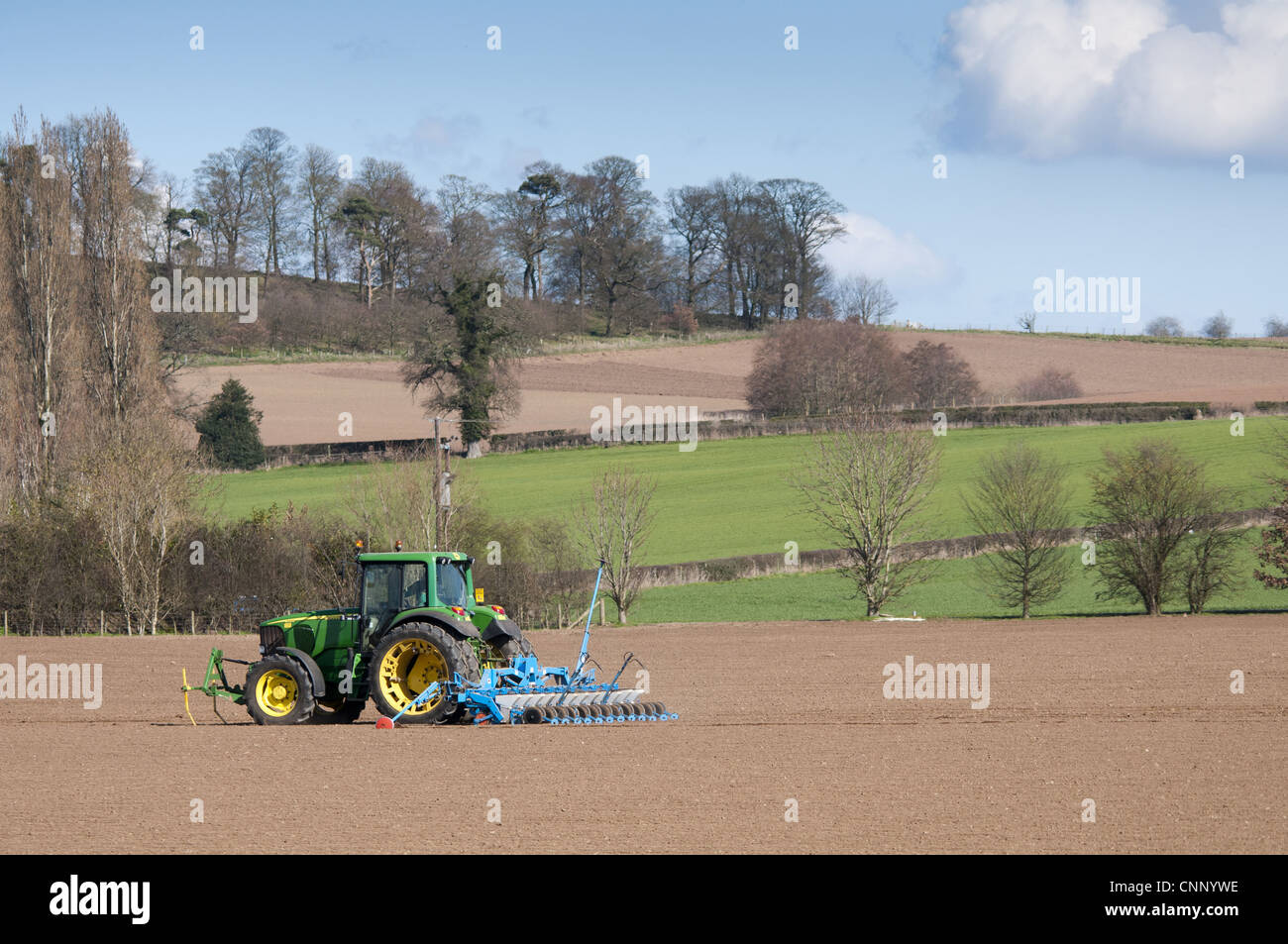 John Deere tractor with seed drill, drilling sugar beet, Nesscliffe, Shropshire, England, march Stock Photo
