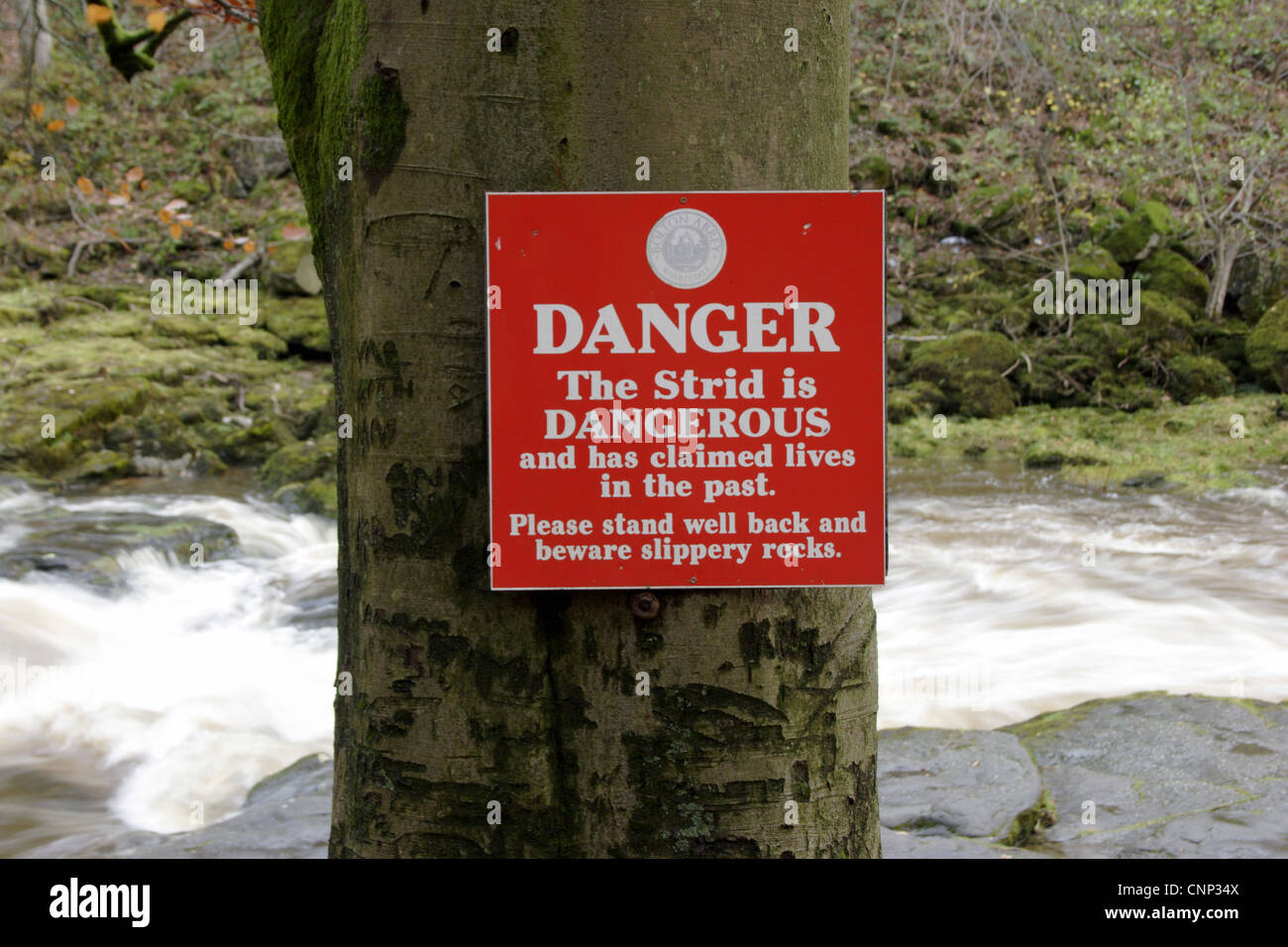 Danger Strid Dangerous' warning sign beside fast-flowing river Strid River Wharfe Bolton Abbey Estate Wharfedale Yorkshire Stock Photo