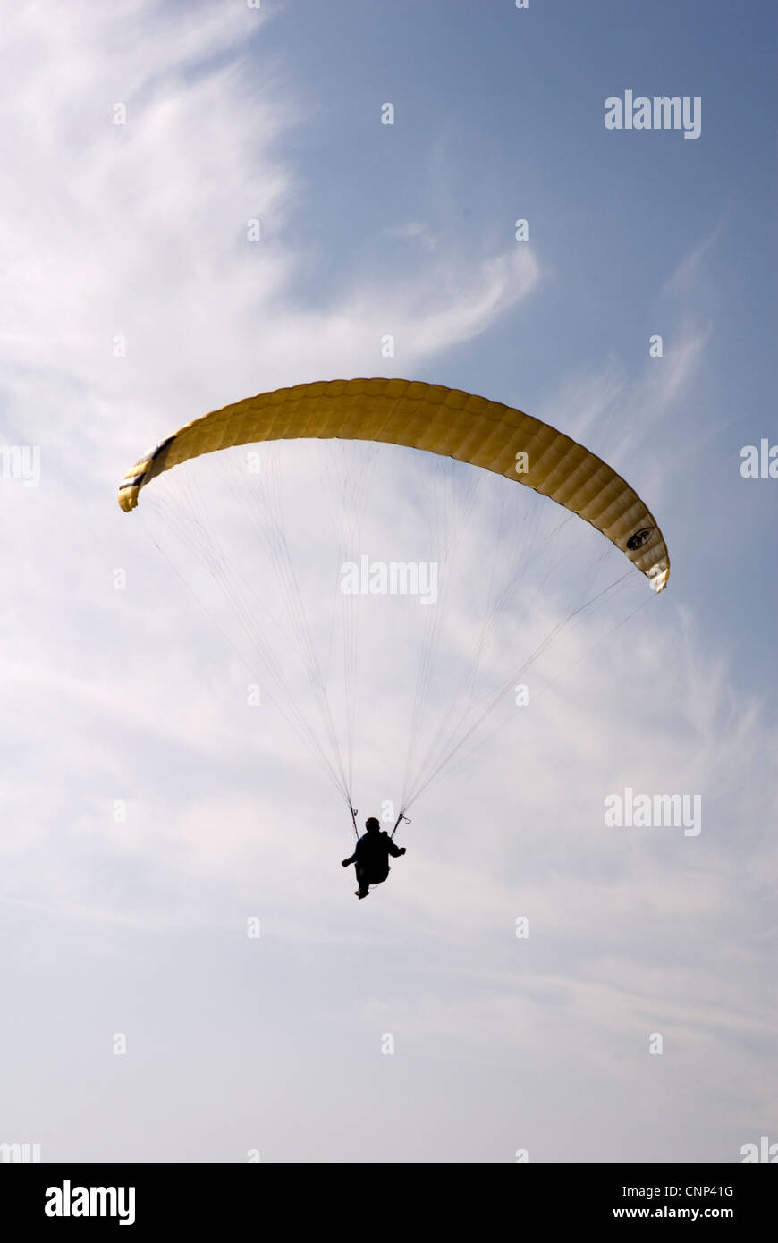 Para glider - seen against blue/white mottled sky - riding a thermal updraft Stock Photo