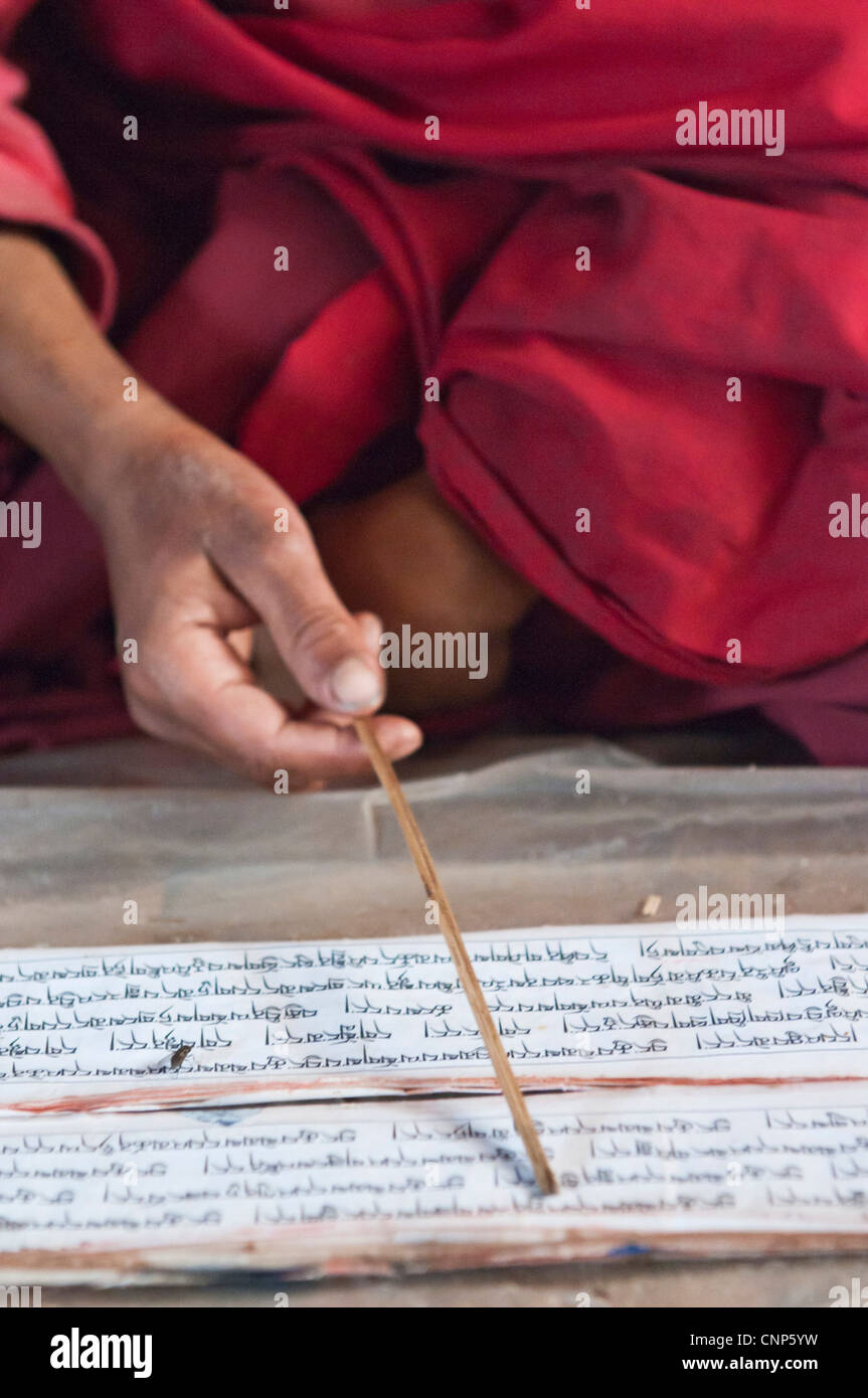 Asia, Bhutan. Young monk points to words in chant book in the Temple of the Divine Madman Stock Photo