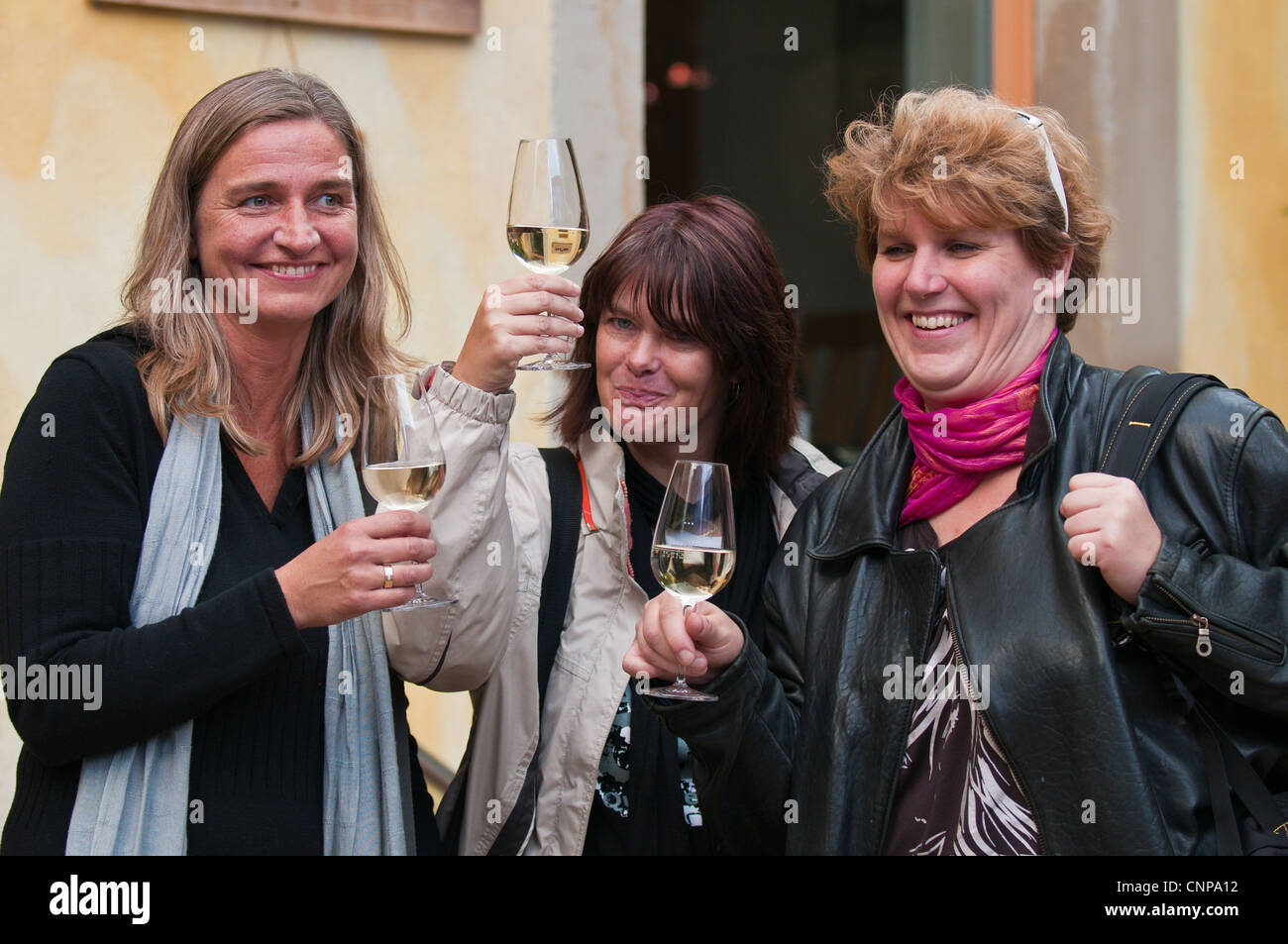 Women drinking white wine glasses Bohemian neighbourhood in the Outer Neustadt district of Dresden, Germany. Stock Photo