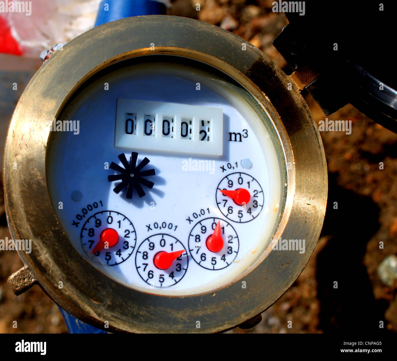 Close up image of a newly installed brass water meter in a suburban village. Stock Photo