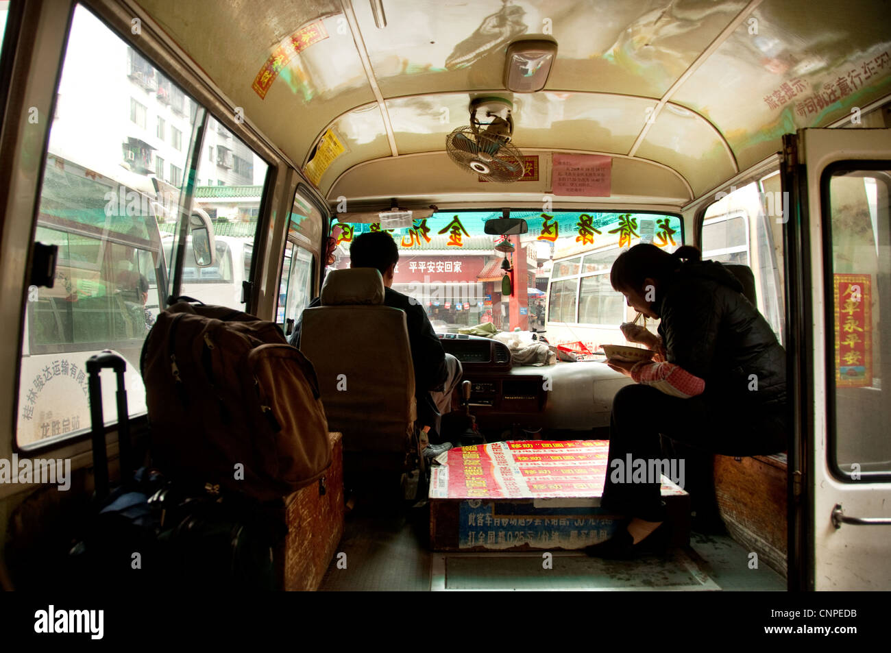 A woman eating from a pot on a bus, Southern China Stock Photo Alamy