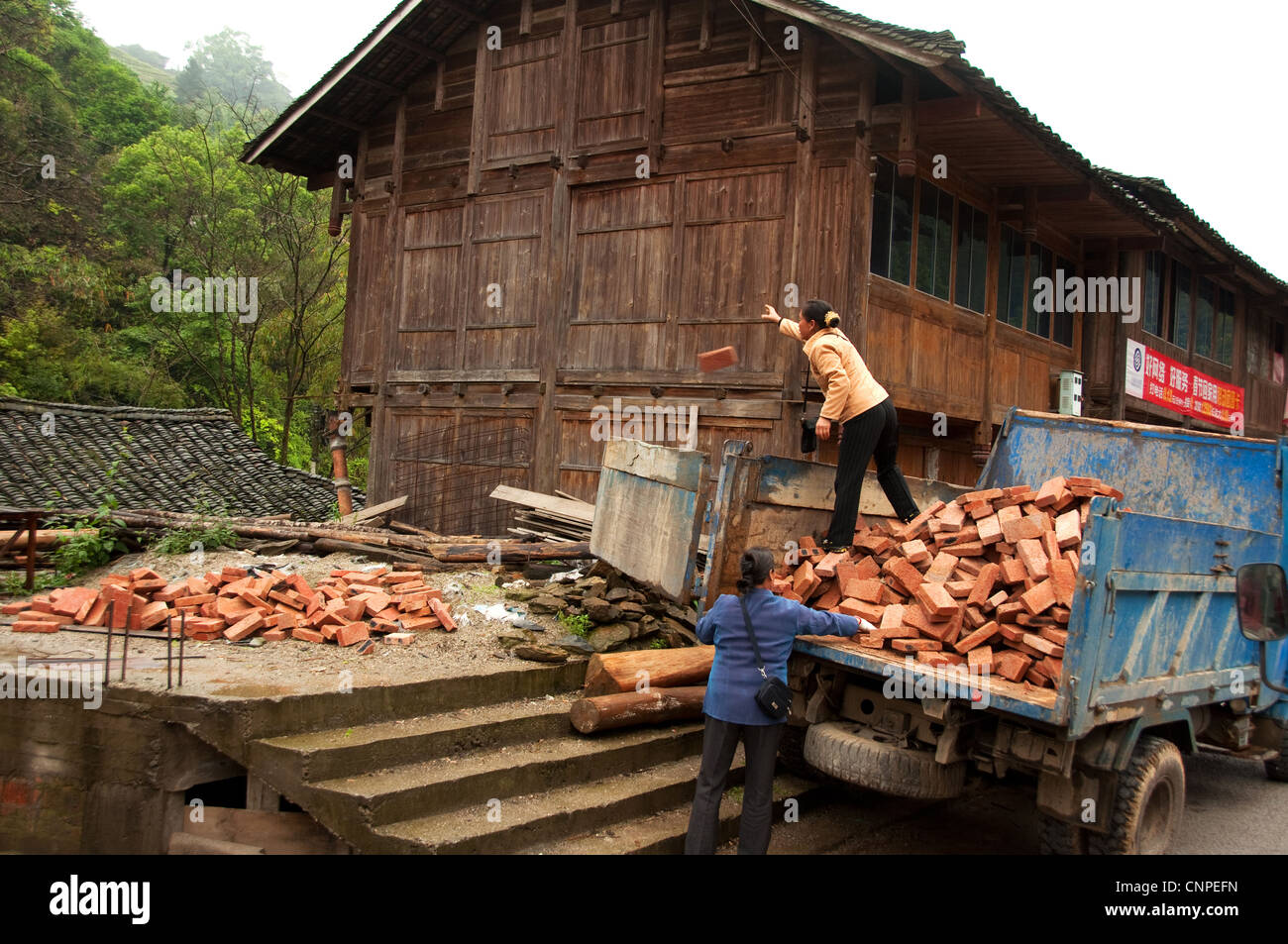 Two women unloading bricks from a truck, Southern China Stock Photo