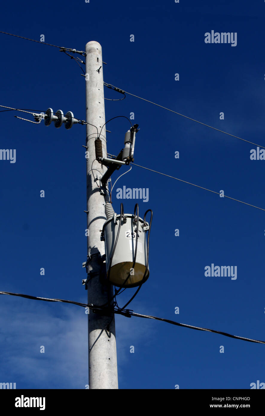 A single electric power transformer against a clear blue sky. Stock Photo