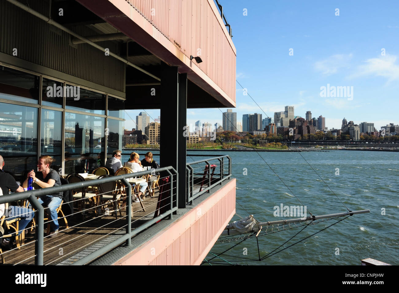 Blue sky view, to Brooklyn Skyline, people sitting relaxing, Harbour Lights Restaurant, Pier 17, South Street Seaport, New York Stock Photo