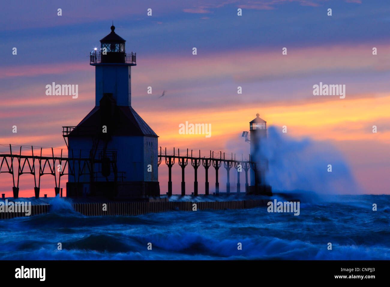 Photo of the St. Joseph Pier at sunset with crashing waves, Lake Michigan, United States Stock