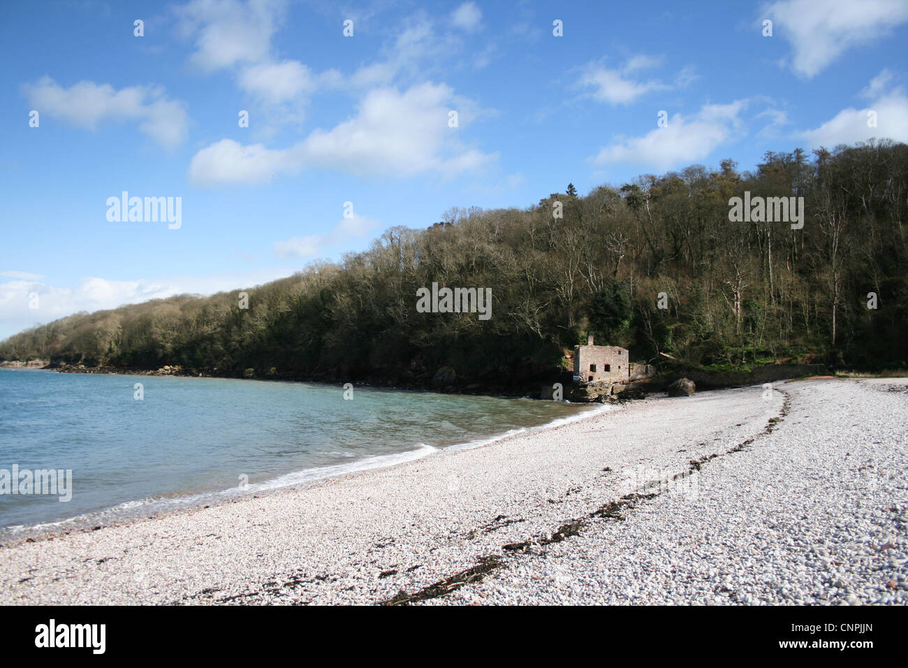 Pebbled Beach in Devon UK, with old derelict building at end of the ...
