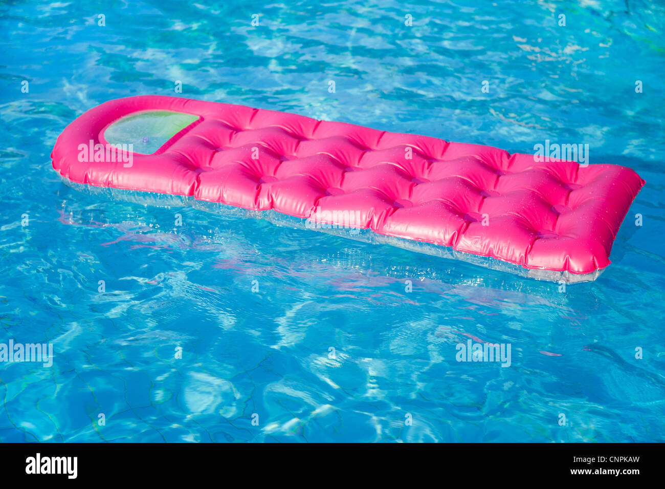 Floating pink and green air mattress in swimming pool Stock Photo - Alamy