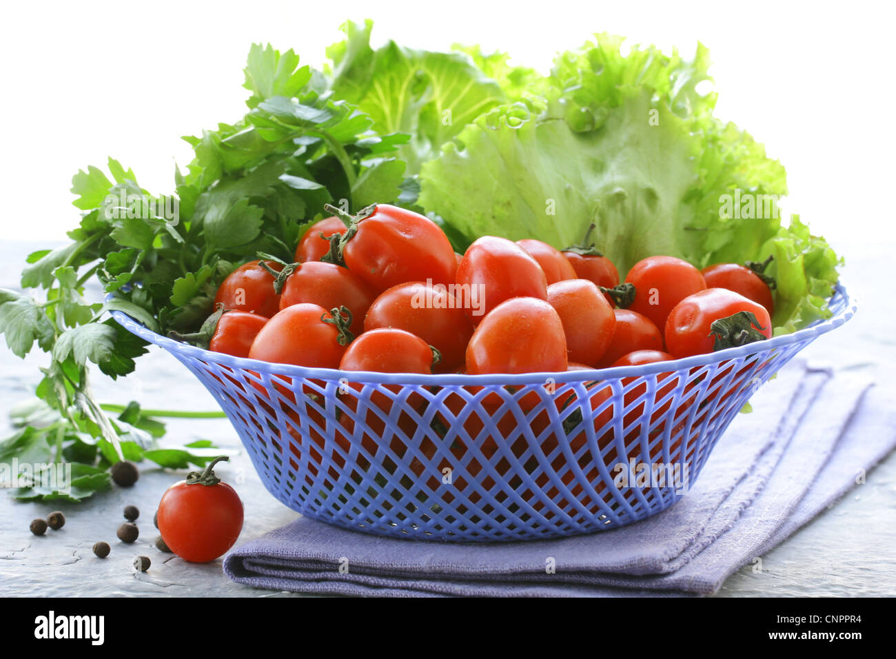 Cherry tomatoes and herbs in a wicker basket Stock Photo - Alamy