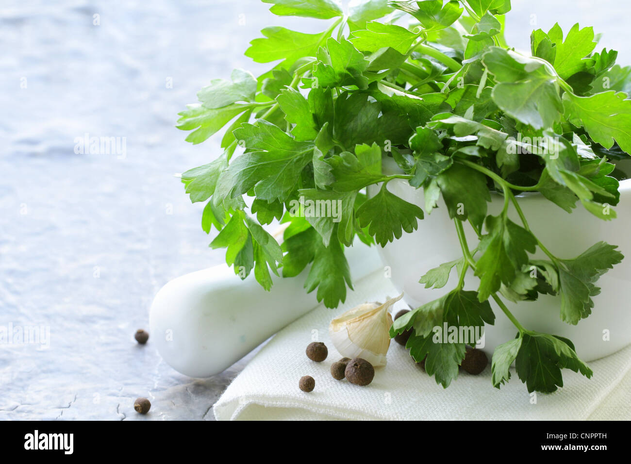 green parsley in a mortar with garlic and pepper Stock Photo