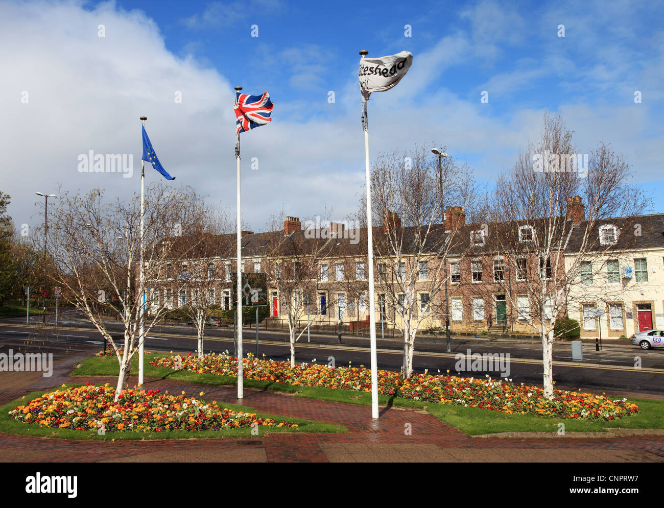 Spring flowers display and flags flying outside Gateshead Civic Centre, north east England UK Stock Photo