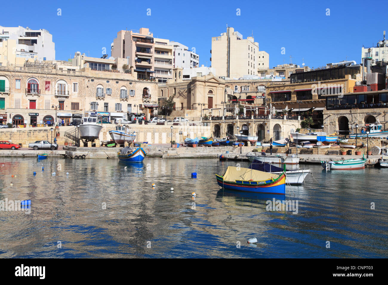 Fishing boats and historic buildings within Spinola Bay, St Julian's  Malta Europe Stock Photo