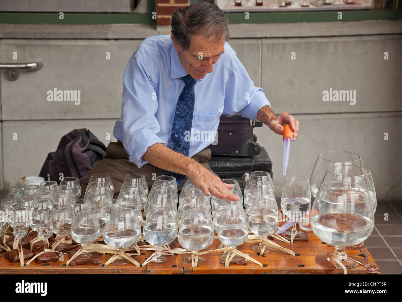 Man making music with water glasses Stock Photo Alamy
