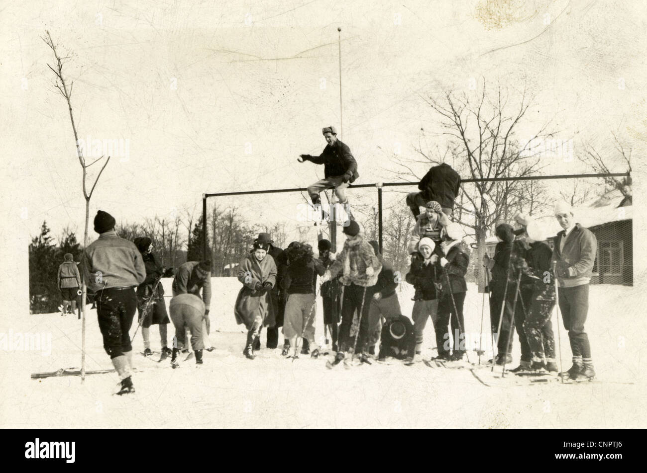 Circa 1930s photograph, group of college students having a snowball fight before a cross country ski trip. Stock Photo