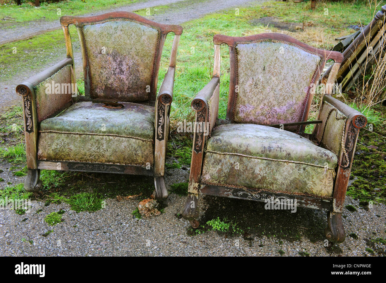a pair of rotting old armchairs out in the weather Stock Photo