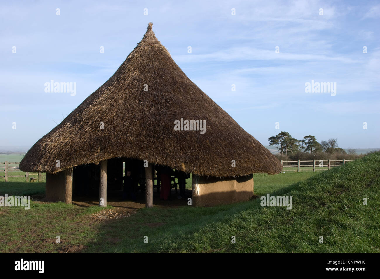 Iron age mud hut roundhouse with mud walls and conical thatched roof Stock Photo
