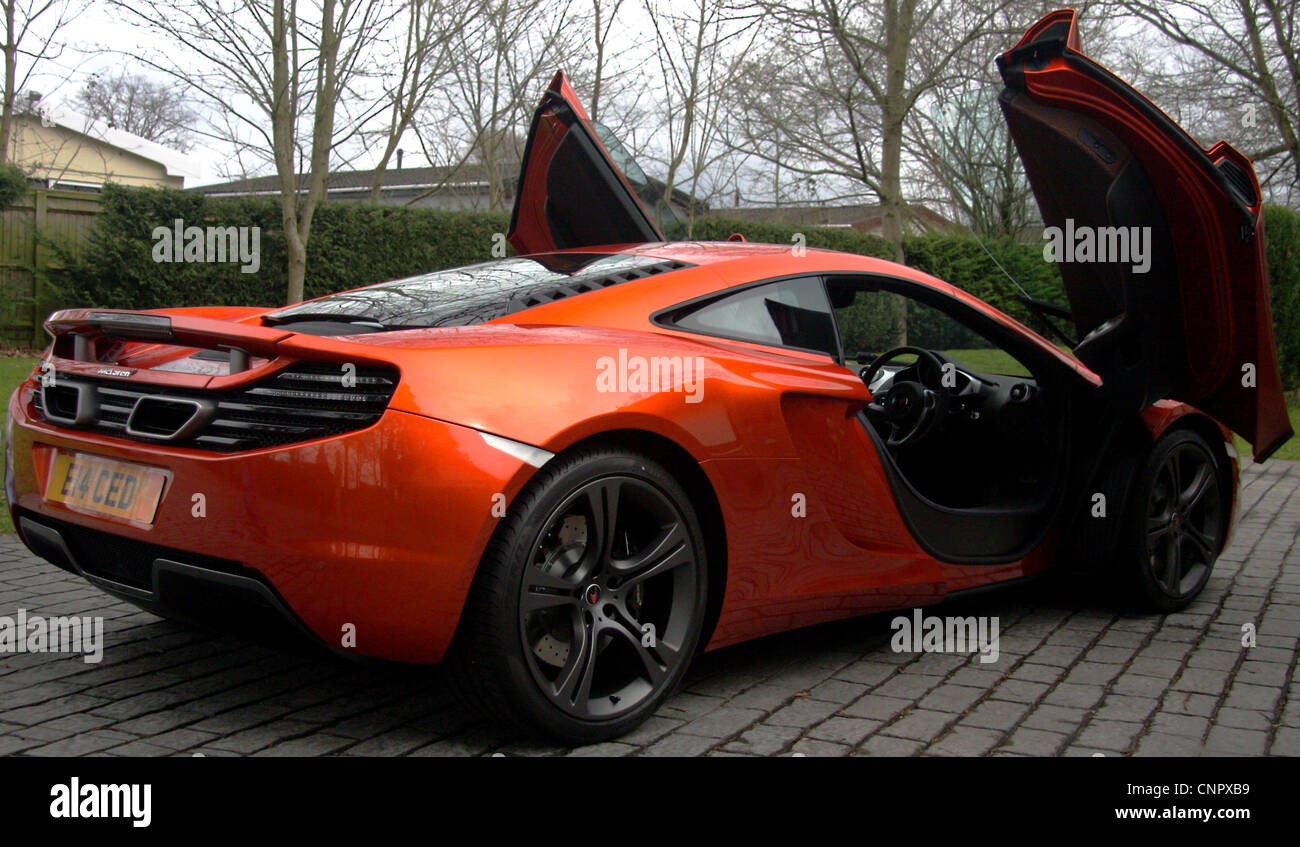 A new McLaren MP4-12C on a driveway with the doors open. Stock Photo
