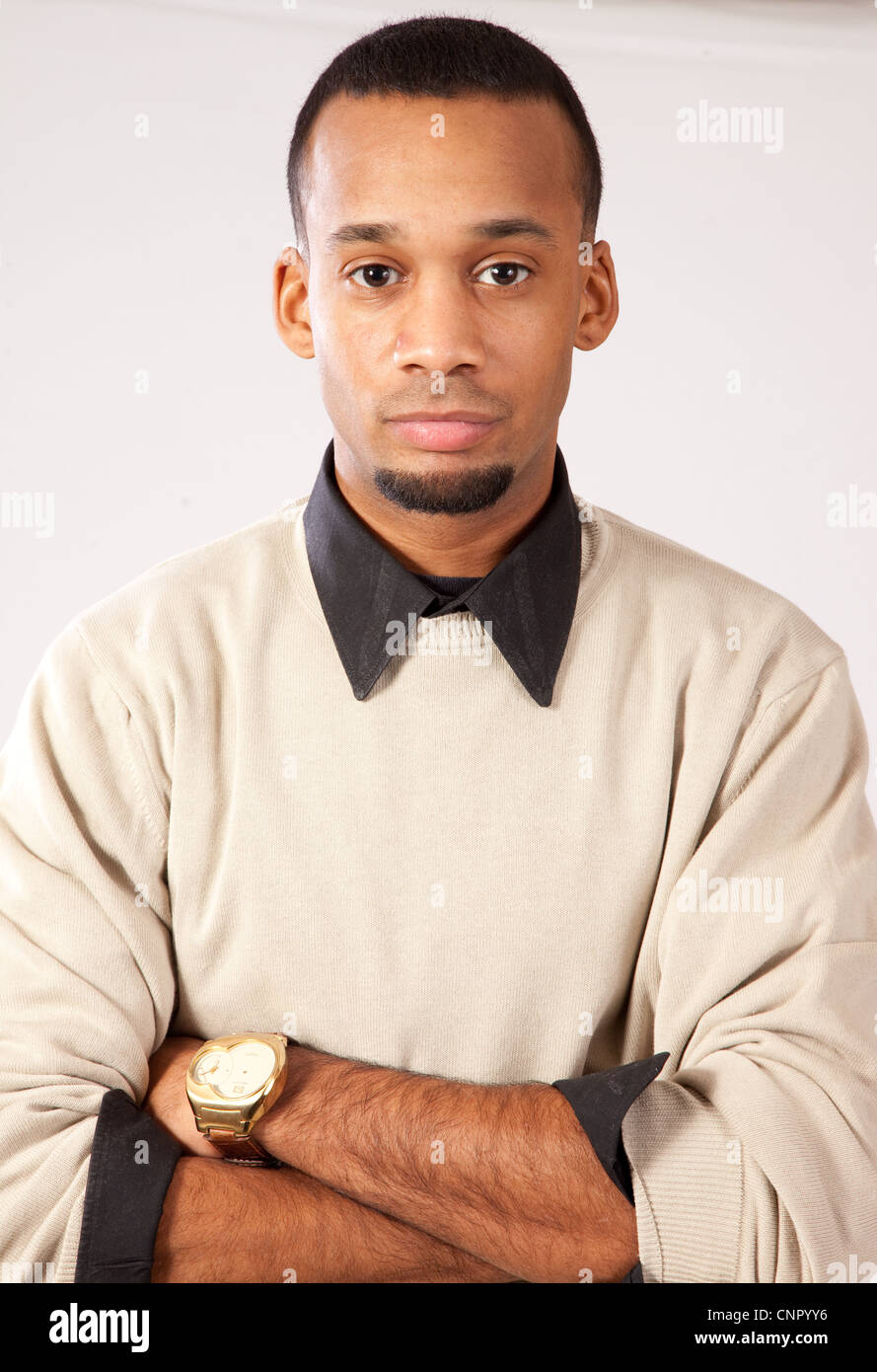 Handsome young black man with pensive expression and arms folded, facing front with a thoughtful expression Stock Photo