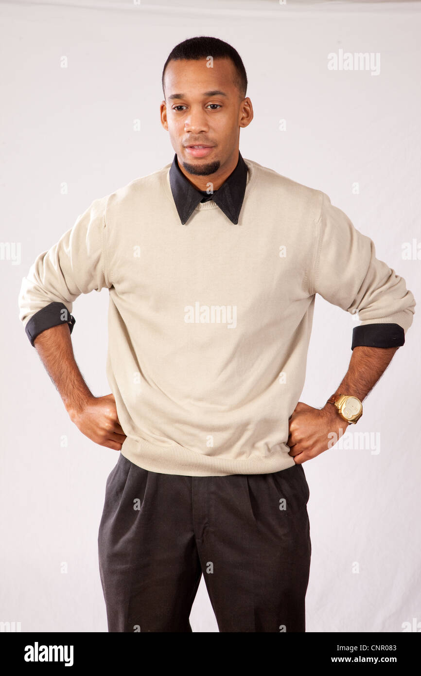 Thoughtful young black man, wearing sweater and looking all pensive and sad  with his hands on his hips Stock Photo