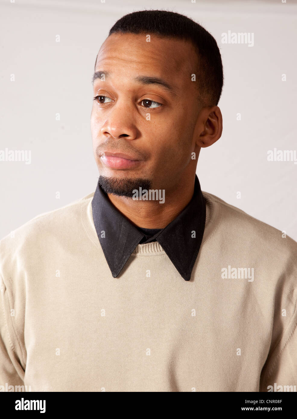 Thoughtful young black man, wearing sweater and looking all pensive and sad Stock Photo