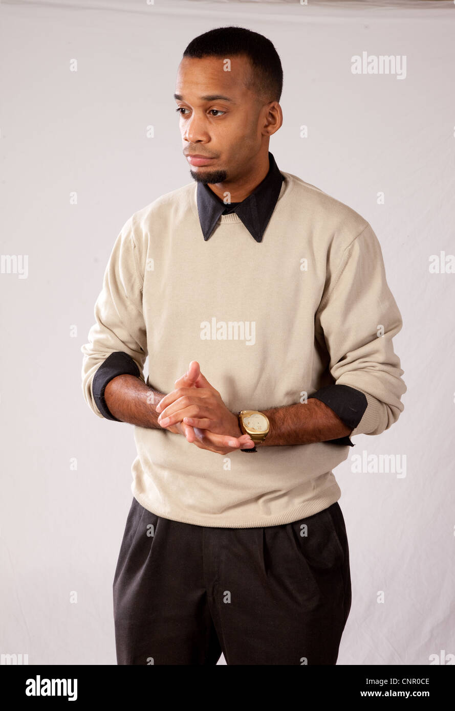 Thoughtful young black man, wearing sweater and looking all pensive wringing his hands Stock Photo