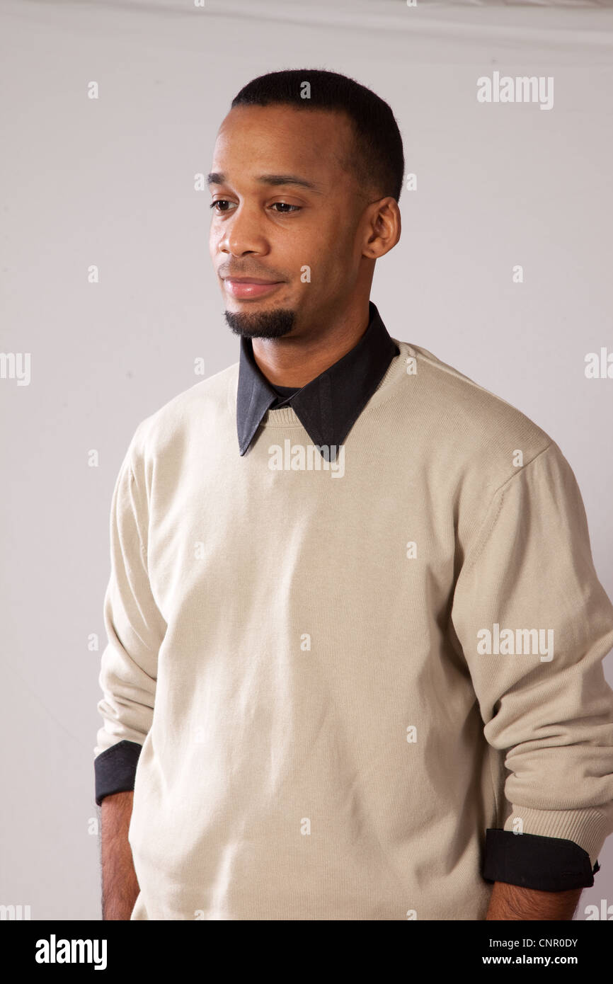 Thoughtful young black man, wearing sweater and looking all pensive with a hint of a smile Stock Photo