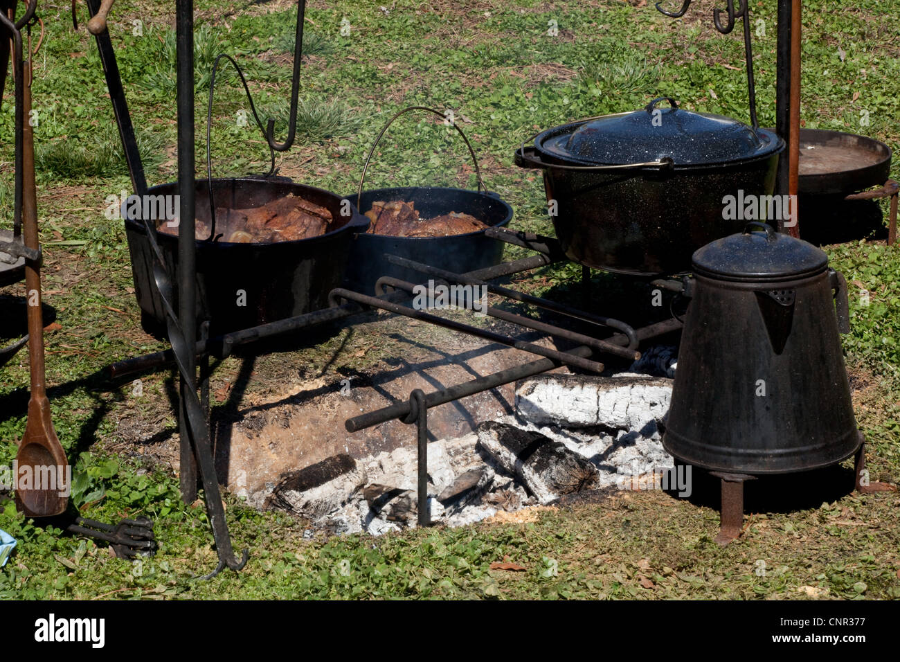 Cooking over a camp fire, with cast iron pots and coffee pot, outdoors