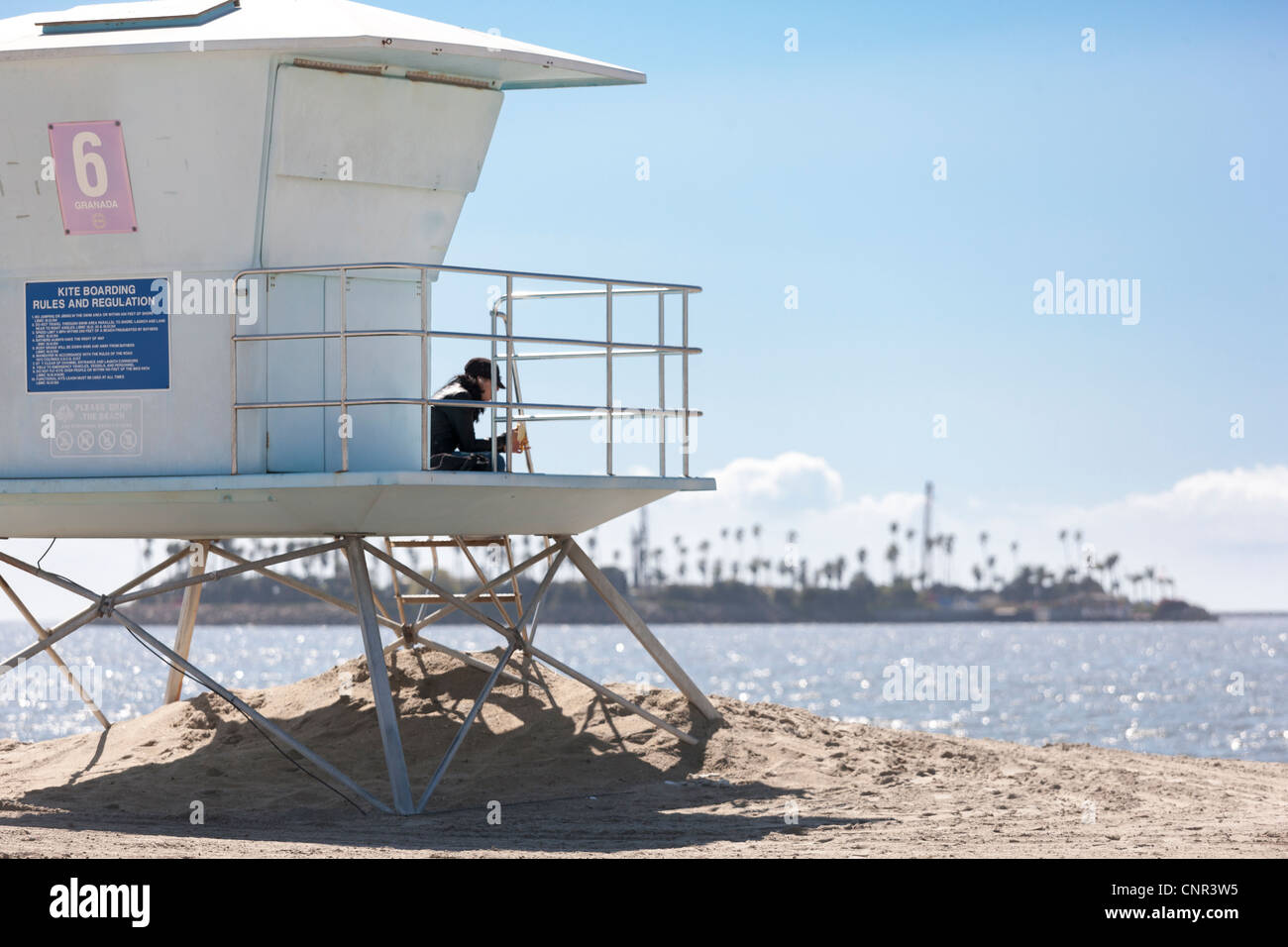 Life guard lifeguard station hut in Long Beach Ca California with Island Chaffee an offshore oil rig disguised with palm trees Stock Photo